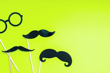 Creative flatlay overhead top view retro stylish black paper photo booth props moustaches lime green background copy space. Men health awareness month fathers day masculinity concept blog social mediaの写真素材