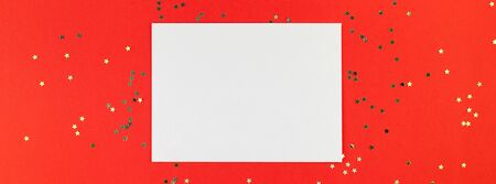Creative New Year or Christmas greetings letter mockup flat lay top view Xmas holiday celebration envelope on red paper background golden glitter. Template mock up long wide banner 2020の写真素材
