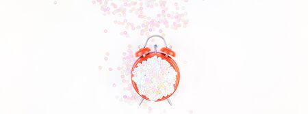 Pearl pastel confetti sparkles with red alarm clock on white background. Creative conceptual top...