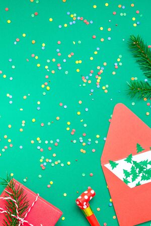 New Year or Christmas pattern flat lay top view with red alarm clock twelve midnight fir tree branch Xmas holiday celebration green paper bright colorful confetti background. Template text design 2020の写真素材