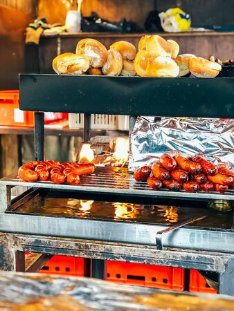 Christmas market in Germany, Europe. Traditional bratwurst sausages and bread on grill during outdoor seasonal Christmas market in Munichの写真素材