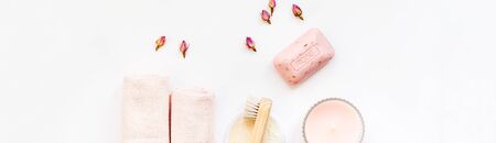 Spa, beauty cosmetics and body care treatment concept with copy space. Creative top view flat lay composition with bath accessories, organic DIY rose soap, flowers and candle on white backgroundの写真素材