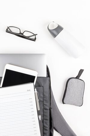 Creative top view flat lay of open backpack with laptop and tablet inside, mobile phone, copy space...