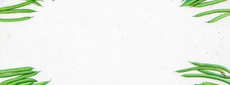 Creative scandinavian style flat lay top view of fresh green beans on white concrete table background copy space. Minimal house cooking concept template for blog or recipe bookの写真素材