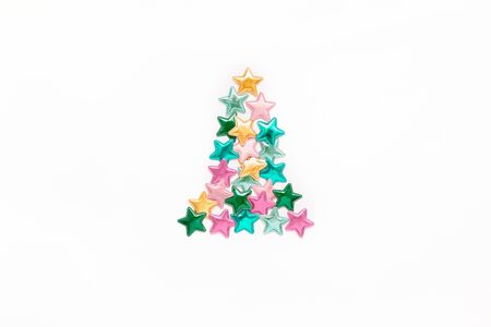Christmas composition. New Year pattern flat lay top view Xmas holiday celebration decorative color stars Christmas tree concept on white background with copy space. Template of greeting cardの写真素材