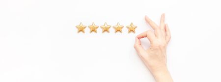 Customer Experience Feedback Concept. Golden five 5 stars, best excellent services rating with woman hand for satisfaction isolated on white background. Top view, copy space for your textの写真素材