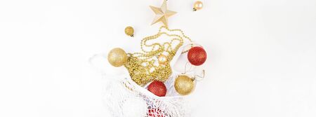 Christmas composition. New Year or Christmas flat lay top view Xmas holiday decorative golden toys in Eco-friendly shopping mesh bag on white background with copy space. Template of greeting cardの写真素材