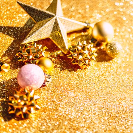Christmas composition. New Year or Christmas pattern flat lay top view Xmas holiday celebration sparkling golden decoration on golden background with copy space. Template of greeting cardの写真素材