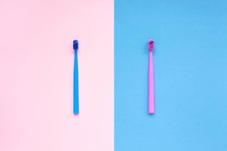 Teeth hygiene and oral dental care products on color pink and blue background with copy space. Toothbrushes Flat lay, top view composition, Family morning conceptの写真素材