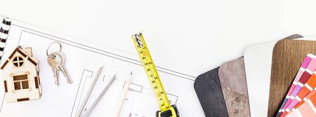 Creative flat lay overhead top view blueprint flat project plan and office supplies on decorator table workspace swatches tools and equipment background copy space conceptの写真素材