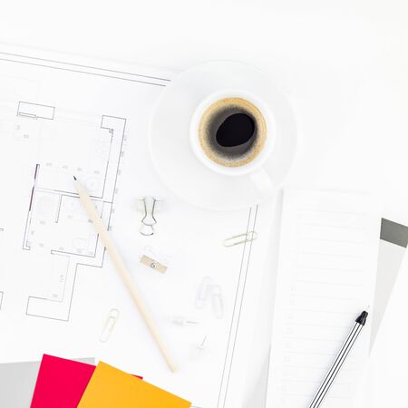 Creative flat lay overhead top view blueprint flat project plan hot coffee cup alarm clock and office supplies on decorator table workspace swatches tools and equipment background copy space conceptの写真素材