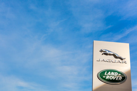 Jaguar Land Rover brand logo on bright blue sky background located on its dealer office building in Lyon, France - February 23, 2020のeditorial素材