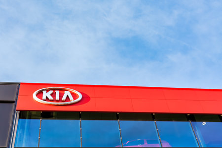 Kia motors corporation brand logo on bright blue sky background located on its dealer office building in Lyon, France - February 23, 2020のeditorial素材