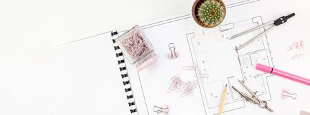 Blueprint flat project plan and office supplies on decorator table workspace. Swatches, tools and...