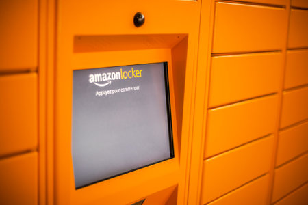 Amazon Locker in shopping mall, orange pick up point for mail order goods with Amazon brand logo on...