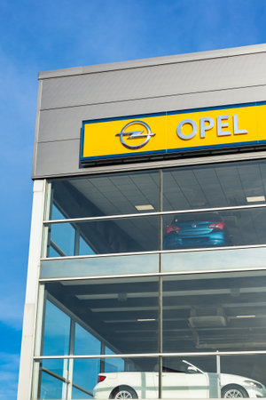 Opel brand logo on bright blue sky background located on its dealer office building in Lyon, France - February 23, 2020のeditorial素材