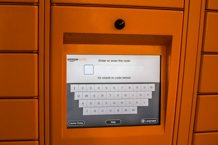 Amazon Locker in shopping mall, orange pick up point for mail order goods with Amazon brand logo on...