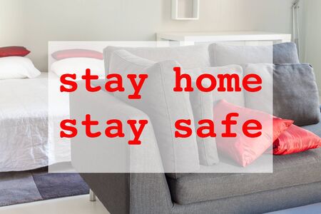 Stay home stay safe concept with flat interior and red text. Spending time home during Coronavirus pandemic quarantine isolation.の写真素材