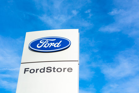 Ford Motor Company brand logo on bright blue sky background located on its car dealer office building in Lyon, France - February 23, 2020のeditorial素材