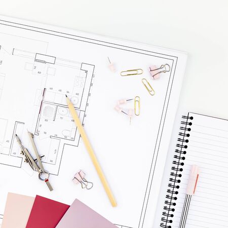 Blueprint flat project plan and office supplies on decorator table workspace. Swatches, tools and...