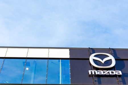 Mazda brand logo on bright blue sky background located on its dealer office building in Lyon, France - February 23, 2020のeditorial素材