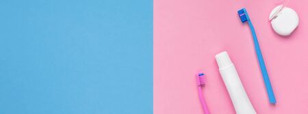 Teeth hygiene and oral dental care products on color pink and blue background with copy space. Blank tube of toothpaste and brushes. Flat lay, top view composition, mockup. Morning conceptの写真素材