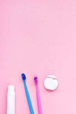 Teeth hygiene and oral dental care products on color pink and blue background with copy space. Blank tube of toothpaste and brushes. Flat lay, top view composition, mockup. Morning conceptの写真素材