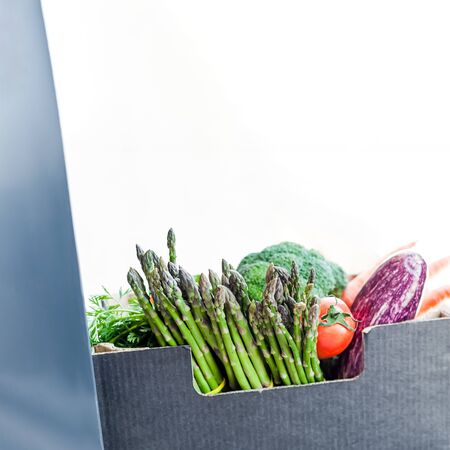 Fresh organic greens and vegetables safe contactless delivery during coronavirus Covid-19 pandemic outbreak. Box with grocery delivering left in the house doorwayの写真素材