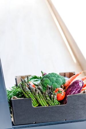 Fresh organic greens and vegetables safe contactless delivery during coronavirus Covid-19 pandemic outbreak. Box with local farmer grocery delivering left in the house doorway. Care package, donationの写真素材