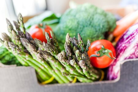 Fresh organic greens and vegetables safe contactless delivery during coronavirus Covid-19 pandemic outbreak. Box with local farmer grocery delivering left in the house doorway. Care package, donationの写真素材