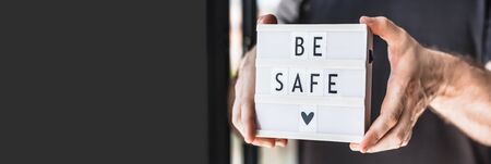 Healthcare and Safety concept. Unrecognised man holding lightbox with text Be safe during coronavirus COVID-19 pandemicsの写真素材