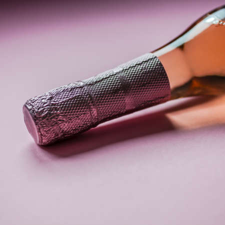 Bottle of rose champagne wine in minimal composition on pink background with copy space. Natural...