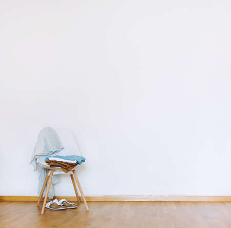 Indoors flat wall mockup with Clothes on Chair in minimalist style. Earthy Neutrals Tones Background. Interior in airy light style with wooden floorの写真素材