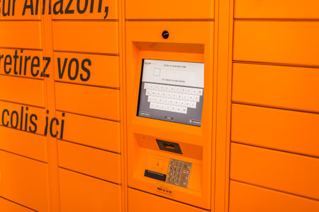 Amazon Locker in shopping mall, orange pick up point for mail order goods with Amazon brand logo on...
