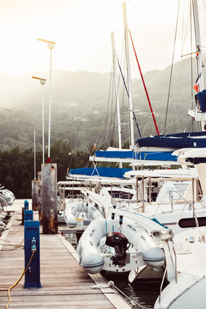 Boats docked at marina with mountain backdrop, suitable for background,の写真素材