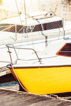 Sailboats moored in sunny marina with vibrant yellow hulls, creating a nautical background,の写真素材