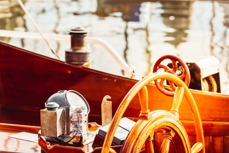 Wooden boat steering wheel and ship details creating nautical atmosphere,の写真素材