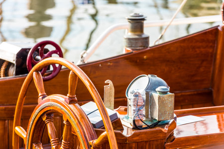Sailboat helm with wooden wheel and nautical equipment in sunlight, background,の写真素材