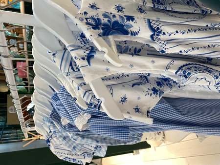 Blue and white patterned shirts hanging on a rack, featuring floral and checkered designsの写真素材
