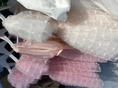 Pink and white dresses with sequins creating a delicate and textured backgroundの写真素材