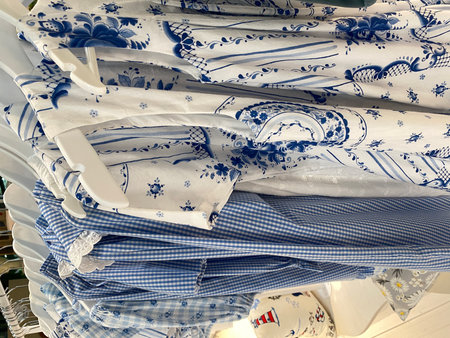 Blue and white patterned fabrics hanging on rack in a clothing store interior environmentの写真素材
