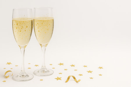 Two glasses of champagne for New Year holiday celebration, with confetti background, AI generatedの素材