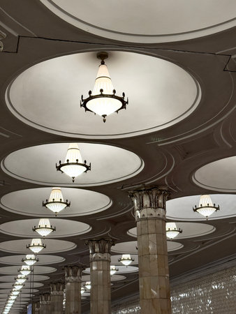 Ceiling with ornate circular light fixtures in elegant architectural space, suitable as background....