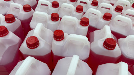 Red and white plastic jugs arranged in rows, viewed from above, creating a pattern background. Mobile photoの写真素材