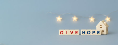 Seasonal charity holiday message with give hope and house on blue background, AI generatedの素材