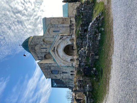 Ancient cathedral with stone ruins and cloudy sky in background, bird in flight, historical site....