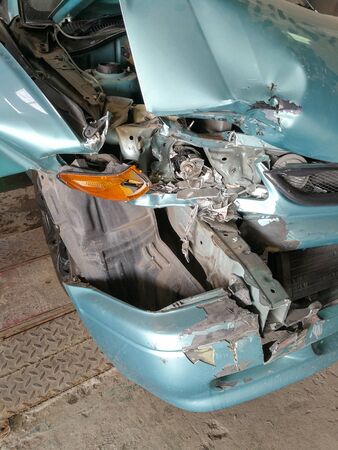 accident crash blue car. Broken engine and bonnet bumper. Headlamp and indicators right side damage.の写真素材