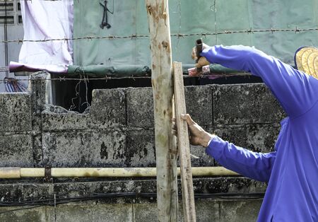worker man use hammer hit nail on wooden together for stronger.の写真素材