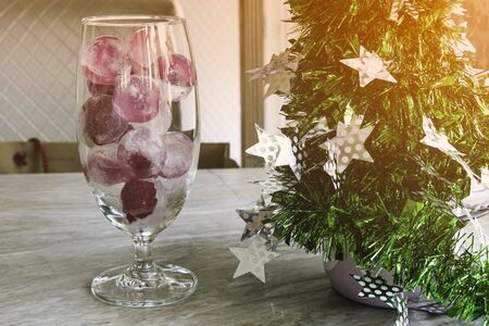 circle flower petals decoration with ice in wine glass. Beauty christmas treeの写真素材