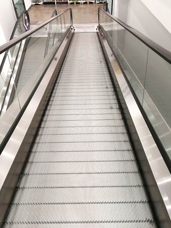 Metal way moving shopping trolley escalator. Nobody going down subway.の写真素材